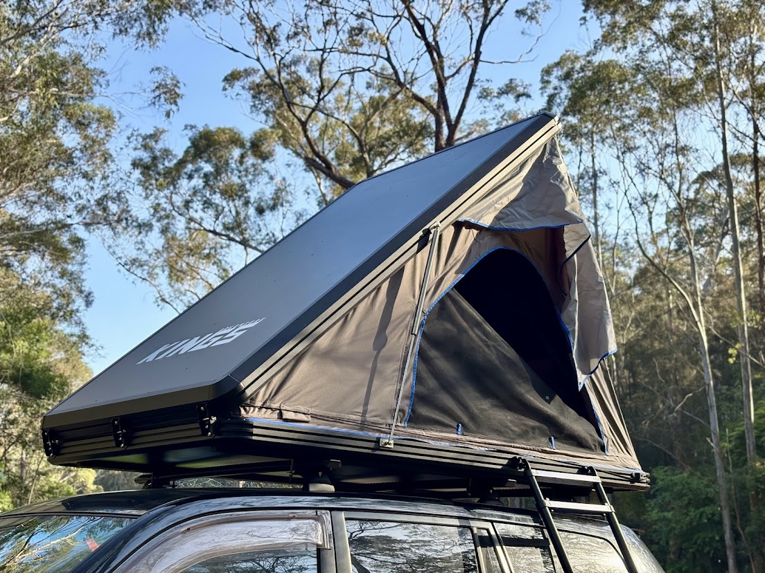 The Adventure Kings Grand Tourer Lite rooftop tent open on the Prado among tall gum trees